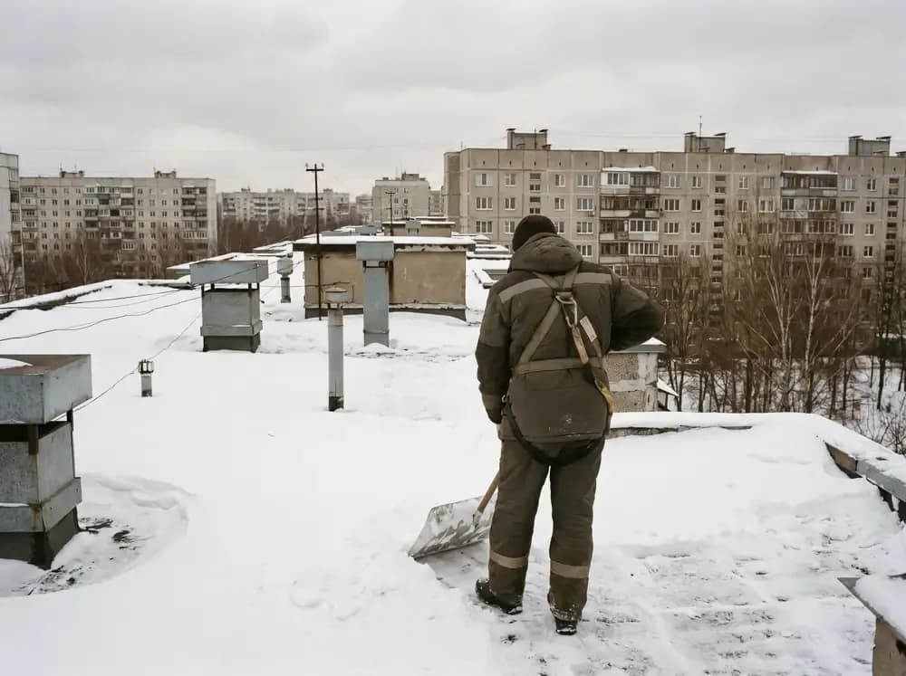 Альпинист чистит плоскую кровлю