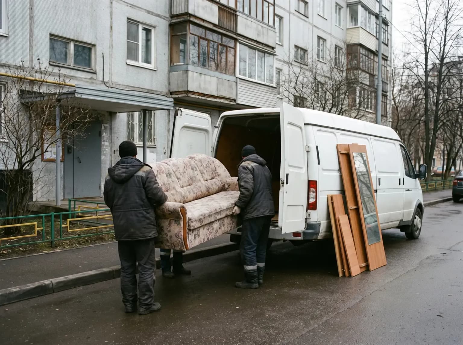 Грузчики выносят старый диван